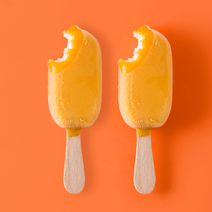 orange and vanilla ice cream pops with a bite taken out of them