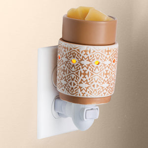 An expressive, intricate pattern is embossed in white clay, filled in with traditional terracotta. Warmer is plugged in to an outlet and has an on/off toggle switch in the front lower portion.