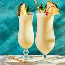 Load image into Gallery viewer, Two tropical Pina colada drinks garnished with pineapple, cherries, and sugar cane sticks

